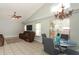 Open living room with a chandelier, glass table, neutral color scheme and plenty of natural light from the windows at 14021 King Sago Ct, Orlando, FL 32828