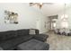 Open-concept living area with gray sectional sofa, wood-look floors, and stylish decor at 14021 King Sago Ct, Orlando, FL 32828