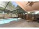 Inviting screened-in pool area with a sparkling pool, mature landscaping, and lounging space at 14021 King Sago Ct, Orlando, FL 32828