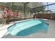 Sparkling screened-in pool with custom tile and surrounded by lush landscaping, perfect for summer fun at 14021 King Sago Ct, Orlando, FL 32828