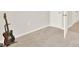 Clean bedroom featuring carpet, baseboard trim, white door and brown electric guitar on stand at 1511 Finnigan Cir, Haines City, FL 33844