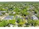 Wide aerial view showing the property in its neighborhood, featuring lush trees and proximity to a small pond at 1633 Pine Ave, Winter Park, FL 32789