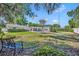 Spacious backyard featuring lush green lawn, mature trees, a swing, and a view of the home's outdoor living area at 1633 Pine Ave, Winter Park, FL 32789