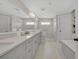 Bathroom featuring dual sinks, white cabinets, a glass shower, and a soaking tub at 1633 Pine Ave, Winter Park, FL 32789