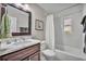 Bathroom with marble vanity, a dark wood cabinet, and a tub with shower at 1633 Pine Ave, Winter Park, FL 32789