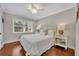 Charming bedroom with a white iron bed frame, hardwood floors, and natural light at 1633 Pine Ave, Winter Park, FL 32789