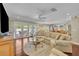Spacious living room with hardwood floors, white sectional sofa, and sliding glass doors to the pool area at 1633 Pine Ave, Winter Park, FL 32789