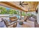 Covered patio with a wood ceiling, brick floors, comfortable seating, and pool views at 1633 Pine Ave, Winter Park, FL 32789