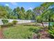 Well-maintained yard with a white fence, mature landscaping, green grass, and mulch beds surrounding various plants at 1633 Pine Ave, Winter Park, FL 32789