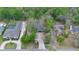 Aerial view of residences showing brick paved driveways and mature landscaping in a wooded area at 1845 Spruce Creek Blvd, Port Orange, FL 32128