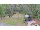 Backyard view of outdoor entertainment area with outdoor shed and wooded area at 1845 Spruce Creek Blvd, Port Orange, FL 32128