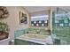 Bright bathroom featuring a tub with green tile surround, glass shower and decorative accents at 1845 Spruce Creek Blvd, Port Orange, FL 32128
