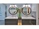 Bathroom featuring dual sinks, decorative mirrors, and modern fixtures at 1845 Spruce Creek Blvd, Port Orange, FL 32128