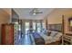 Bright bedroom with a king bed, dark wood floors, and access to the outdoors at 1845 Spruce Creek Blvd, Port Orange, FL 32128