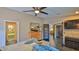 Bedroom features tiled floors, ceiling fan, furnishings, and doorway to an en suite at 1845 Spruce Creek Blvd, Port Orange, FL 32128