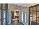 View of a home's entryway featuring tiled floors, glass-paneled doors, and chandelier at 1845 Spruce Creek Blvd, Port Orange, FL 32128