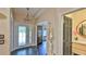 View of entryway featuring tiled floors, chandelier, front door, and arched doorway at 1845 Spruce Creek Blvd, Port Orange, FL 32128