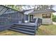 Exterior view of home with a deck, outdoor seating, and screened in porch at 1845 Spruce Creek Blvd, Port Orange, FL 32128