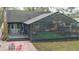 Rear exterior view showcasing screened in porch with deck, and inviting outdoor entertainment space at 1845 Spruce Creek Blvd, Port Orange, FL 32128
