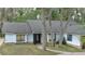 Charming single-story home featuring light blue siding, black window trim and a brick-lined entrance at 1845 Spruce Creek Blvd, Port Orange, FL 32128