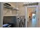 Laundry room with a modern washer and dryer and convenient shelving at 1845 Spruce Creek Blvd, Port Orange, FL 32128