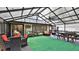 View of the spacious screened-in porch with multiple seating and dining areas at 1845 Spruce Creek Blvd, Port Orange, FL 32128
