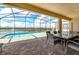 Covered patio boasts a dining table and chairs offering stunning lake views from this well-designed home at 1876 Nice Ct, Kissimmee, FL 34747