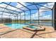 Enclosed pool area features a pool and in-ground spa overlooking the serene lake in this beautiful home at 1876 Nice Ct, Kissimmee, FL 34747