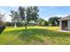 Expansive backyard with lush green grass, mature trees, and serene pond view with water fountain at 2218 Ridgewind Way, Windermere, FL 34786