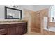 Elegant bathroom with granite countertops, a walk-in shower, and marble tiles at 2218 Ridgewind Way, Windermere, FL 34786
