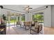 Bright living room with a ceiling fan, large windows, and comfortable seating overlooking the green backyard at 2218 Ridgewind Way, Windermere, FL 34786