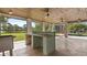 Spacious covered patio featuring an outdoor kitchen and views of the pool and beautifully landscaped yard at 2218 Ridgewind Way, Windermere, FL 34786