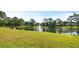 Picturesque pond with a fountain feature, surrounded by well-manicured green space and mature trees at 2218 Ridgewind Way, Windermere, FL 34786