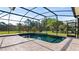 Inviting screened-in pool area surrounded by lush landscaping and a spacious patio at 2218 Ridgewind Way, Windermere, FL 34786
