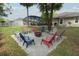 Outdoor patio area around a fire pit with seating, and screened in pool in the background at 30413 Plymouth Creek Cir, Sorrento, FL 32776