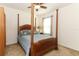 Bedroom featuring a dark wood four poster bed with ceiling fan and a large window providing natural light at 30413 Plymouth Creek Cir, Sorrento, FL 32776