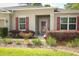 Inviting front entrance with red shutters and a well-maintained landscape, creating a warm curb appeal at 30413 Plymouth Creek Cir, Sorrento, FL 32776