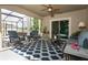 Lanai with ceiling fan, featuring patio furniture including rocking chairs, sofa, tables, outdoor rug and curtains at 30413 Plymouth Creek Cir, Sorrento, FL 32776