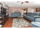 Open living room with blue sofas, a glass coffee table, and wood floors at 30413 Plymouth Creek Cir, Sorrento, FL 32776