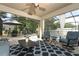A cozy covered patio features comfortable seating, a ceiling fan, and access to the screened-in pool area at 30413 Plymouth Creek Cir, Sorrento, FL 32776