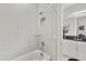 Bathroom featuring tiled shower and bathtub, a glass shelf, and a view into the vanity area at 3144 Players View Cir, Longwood, FL 32779