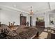 Expansive primary bedroom with dark wood furniture, decorative chandelier and views to backyard at 3144 Players View Cir, Longwood, FL 32779