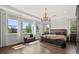 Primary bedroom featuring large windows, plush bedding and stylish chandelier at 3144 Players View Cir, Longwood, FL 32779