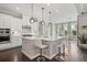 Modern kitchen with white cabinetry, stone backsplash island with seating, and hardwood floors at 3144 Players View Cir, Longwood, FL 32779