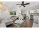 Open-concept living space featuring a sleek wet bar, a modern ceiling fan, and hardwood floors at 3144 Players View Cir, Longwood, FL 32779