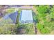 Aerial view of a gray modern home with a flat roof, integral garage, and natural landscaping at 315 E Magnolia St, Davenport, FL 33837
