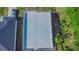 Aerial view shows the home's flat roof, next to well-kept neighboring homes and wooded area at 315 E Magnolia St, Davenport, FL 33837