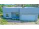 Gray modern home presents a flat roof, attached garage, and a simplistic, unfinished outdoor area at 315 E Magnolia St, Davenport, FL 33837