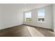 Minimalist bedroom with wood floors, white walls, and two windows providing natural light at 336 Center Lake Ln # A-2, Oviedo, FL 32765