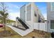 Exterior view of a modern townhome featuring stairs, landscaping, and white privacy walls at 336 Center Lake Ln # A-2, Oviedo, FL 32765
